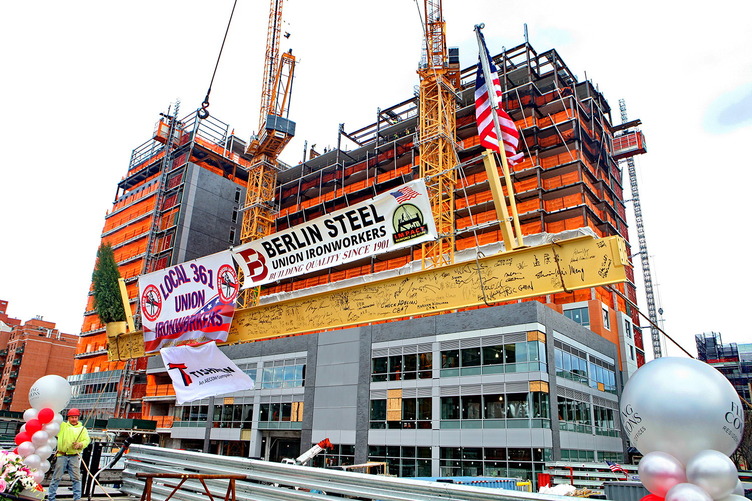 The topping out beam is raised into place at 138-35 39th Avenue at Flushing Commons. Credit: F&T Group