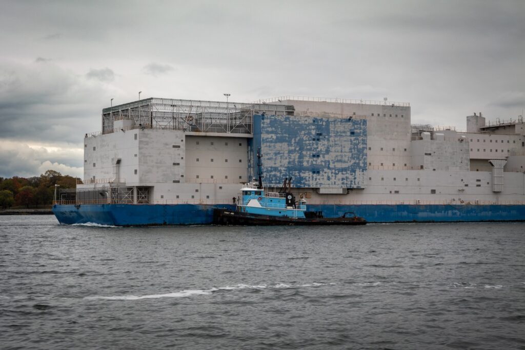 Photograph of the Vernon C. Bain Correctional Center being tugged out of New York City. Credit: NYCEDC.